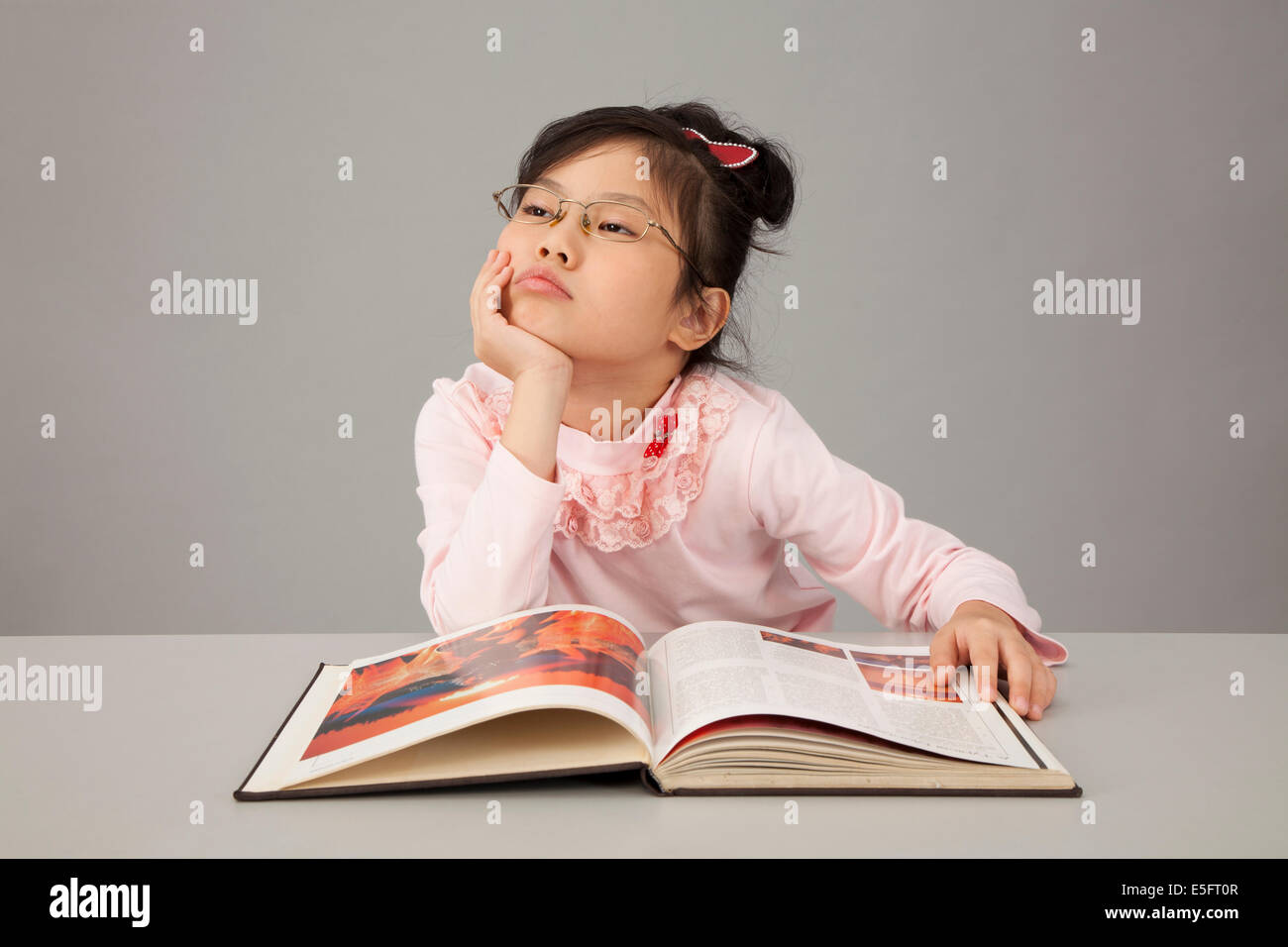 Asian bambina sensazione annoiato studiare Foto Stock