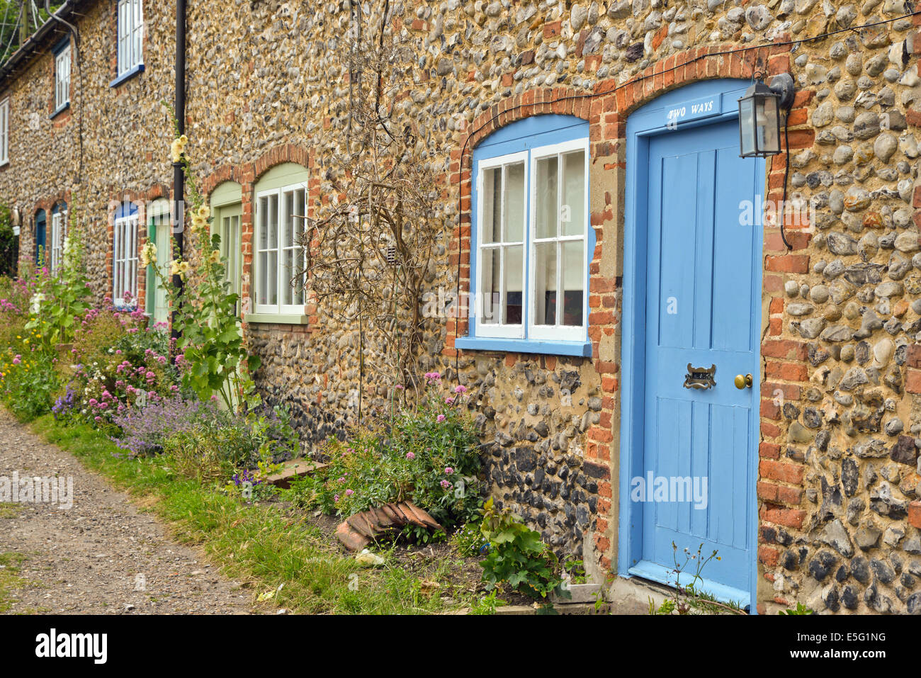 Fila di Cottages in pozzetti accanto il mare Norfolk Regno Unito Foto Stock