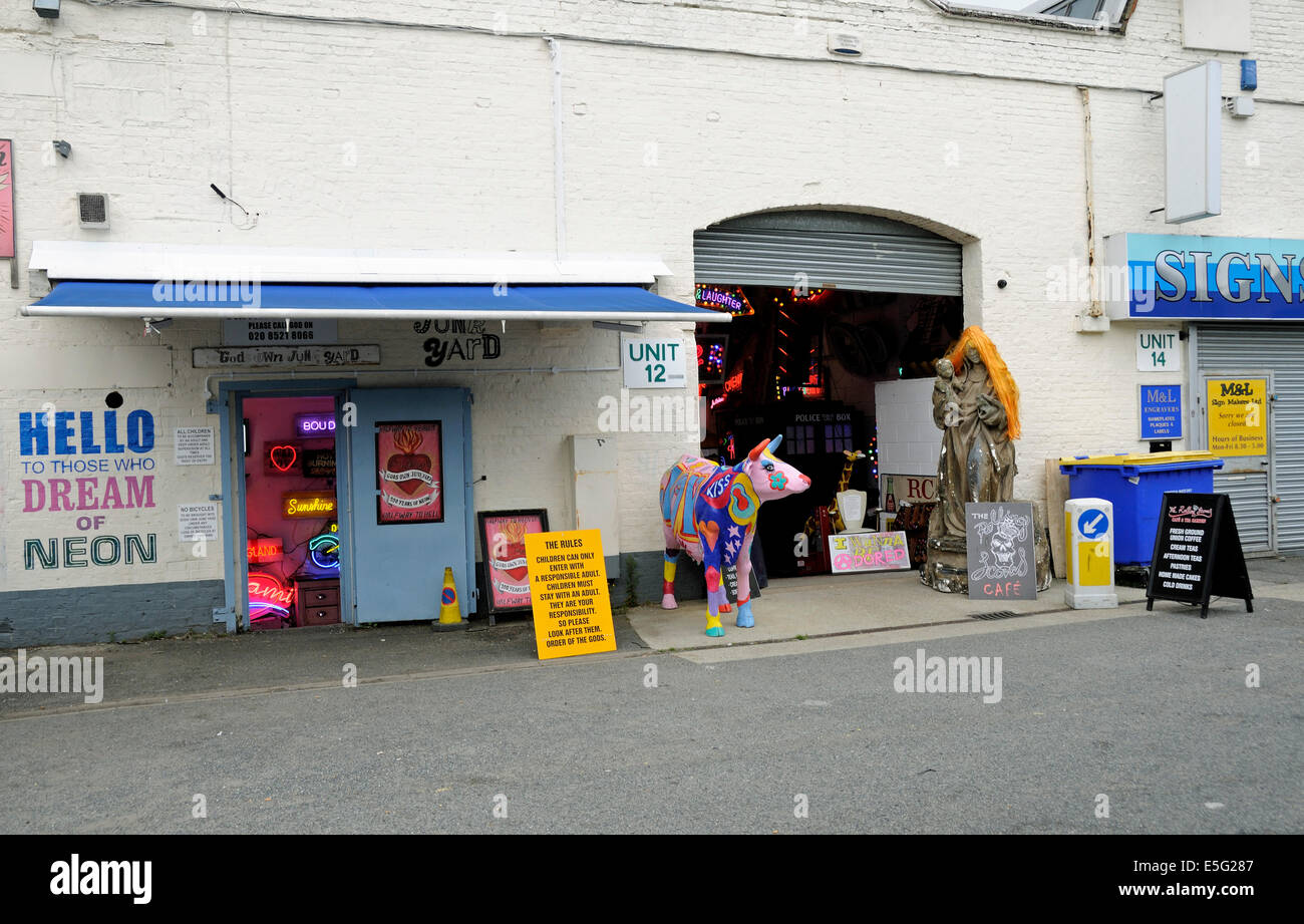 Gli dèi proprio junkyard illuminazione al neon shop accanto alla laminazione Scone Cafe con colorate mucca davanti Walthamstow, London Borough Foto Stock