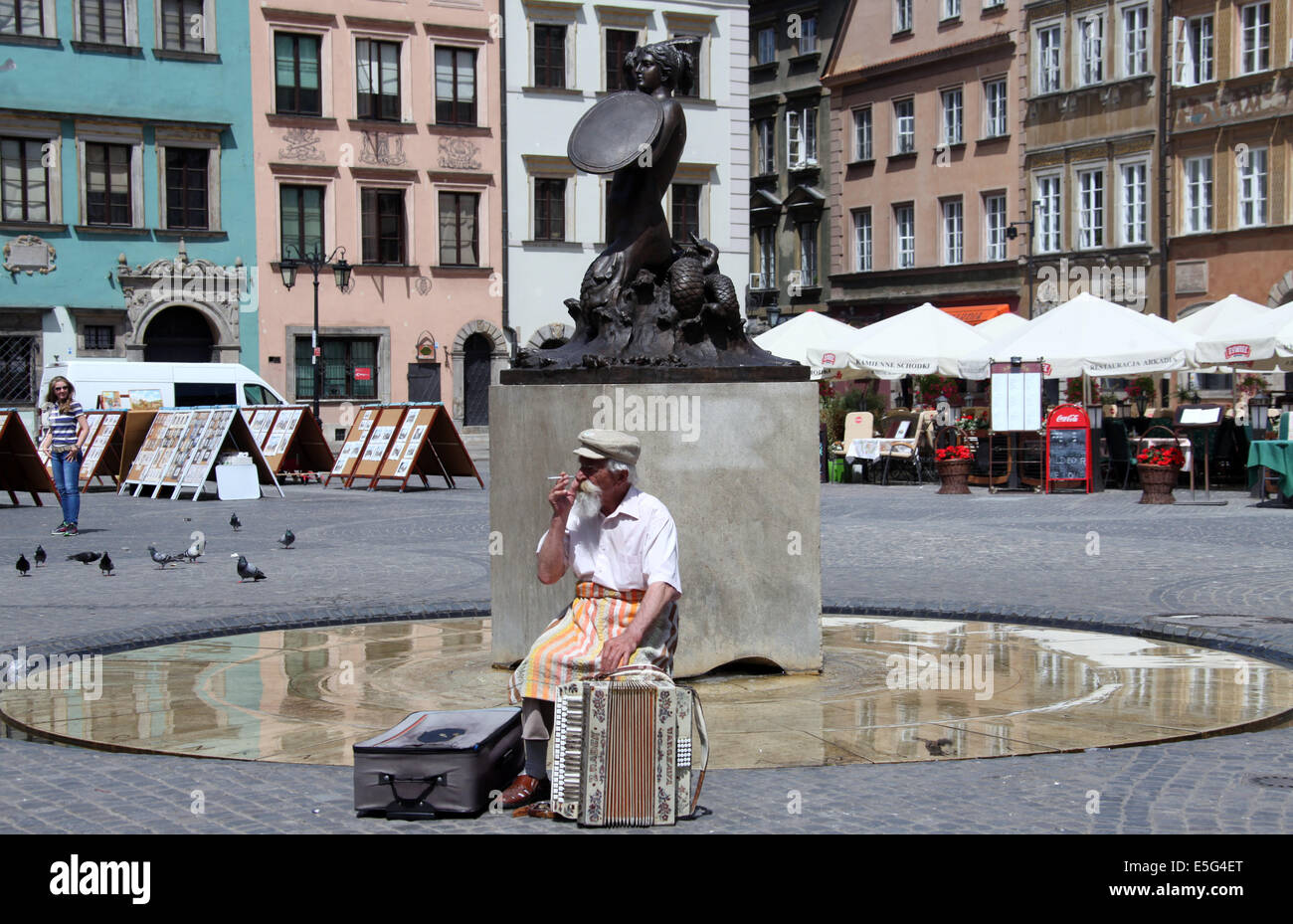 Un fisarmonicista in Varsavia Città Vecchia giocando accanto alla famosa statua di Mermaid Foto Stock