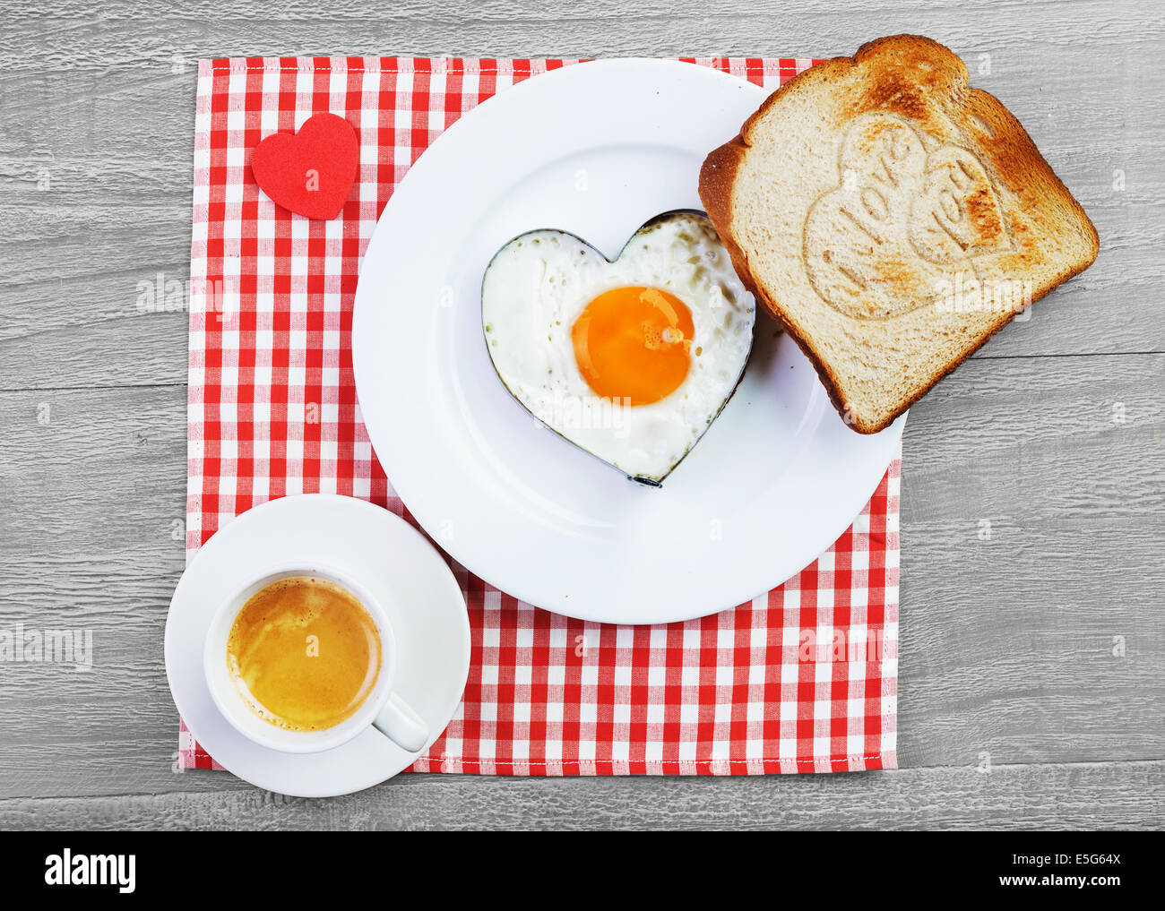 Uovo fritto a forma di cuore e toast con il messaggio di amore.La prima colazione per una persona amata Foto Stock