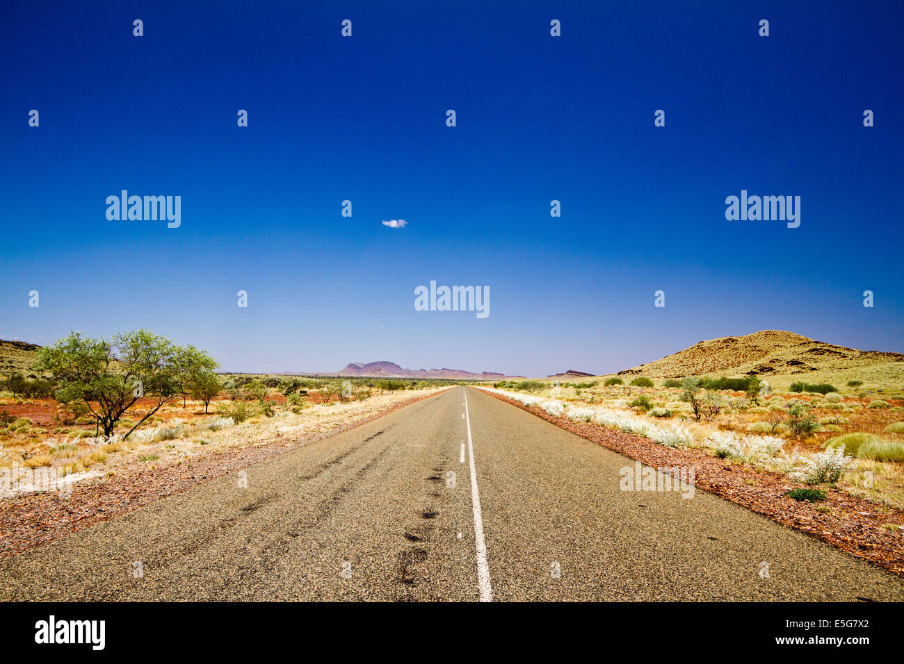 Tipica strada nella regione Pilbara in Western Australia. I colori del paesaggio sono sorprendenti in questa regione. Foto Stock