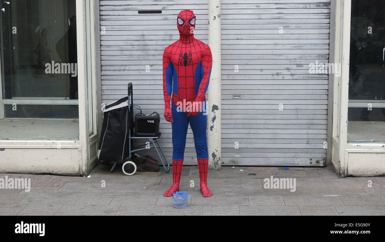 Un uomo vestito come Spiderman sorge su Henry Street nel centro della città di Dublino Foto Stock