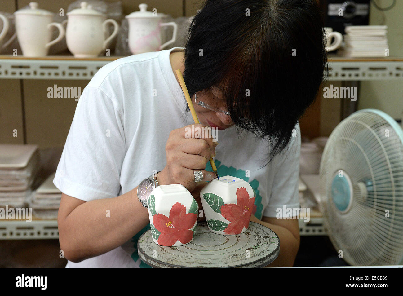 (140731) -- XINBEI, luglio 31, 2014 (Xinhua) -- una donna apprende in ceramica tecnica di pittura in strada Yingge di Xinbei City, a sud-est della Cina di Taiwan, 30 luglio 2014. La storia della produzione ceramica nel Yingge Street ha iniziato circa 200 anni fa, vari tipi di ceramiche fini qui prodotti attraggono molti turisti. (Xinhua/Egli Junchang) (whw) Foto Stock