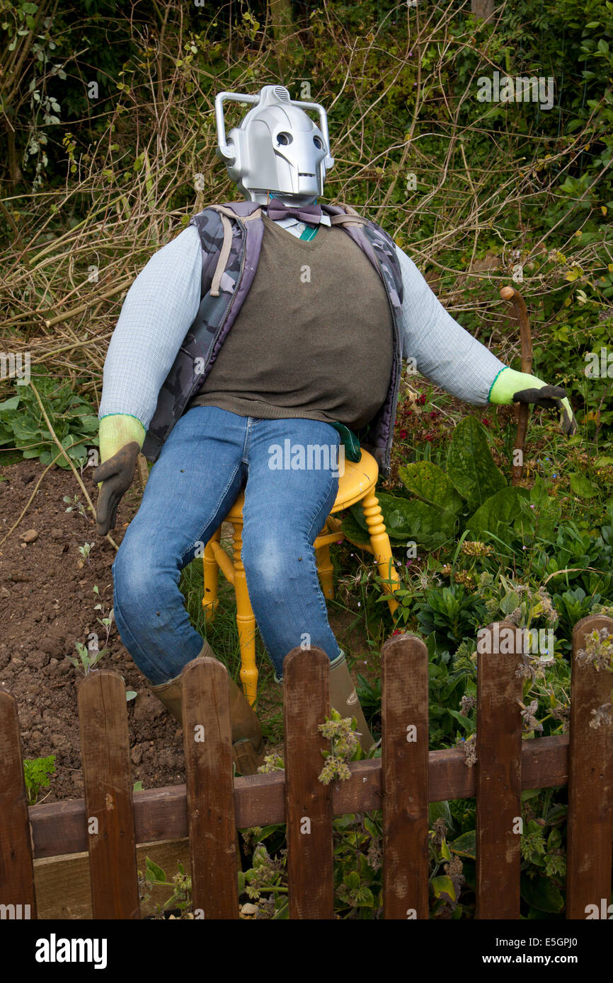 Lo Spaventapasseri con testa cyberman seduto su una sedia in giardino inglese Foto Stock