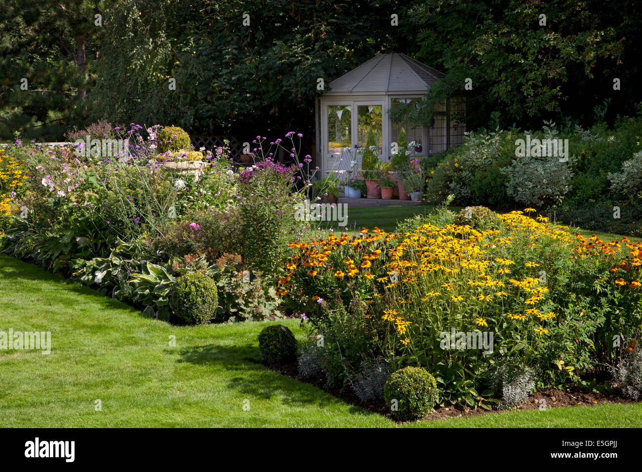 Summerhouse in legno con colorati tarda estate fiore boarder nel Giardino Inglese,Oxfordshire,Inghilterra Foto Stock