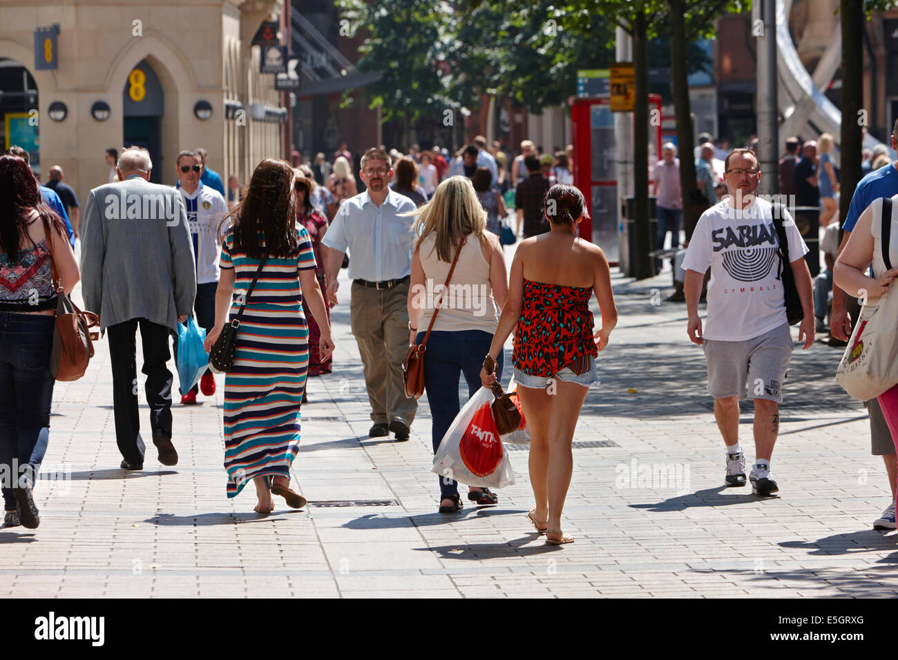 La gente a piedi attraverso occupato cornmarket su una calda giornata di sole a Belfast City Centre Foto Stock