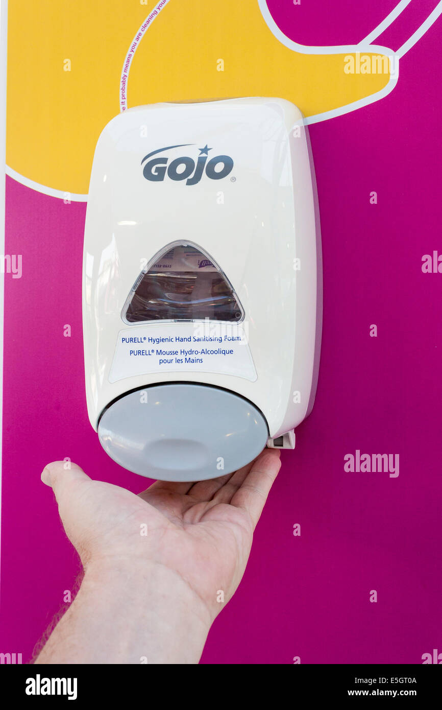 La mano dell'uomo usa la schiuma igienizzante per pulire le mani In ospedale NHS Foto Stock