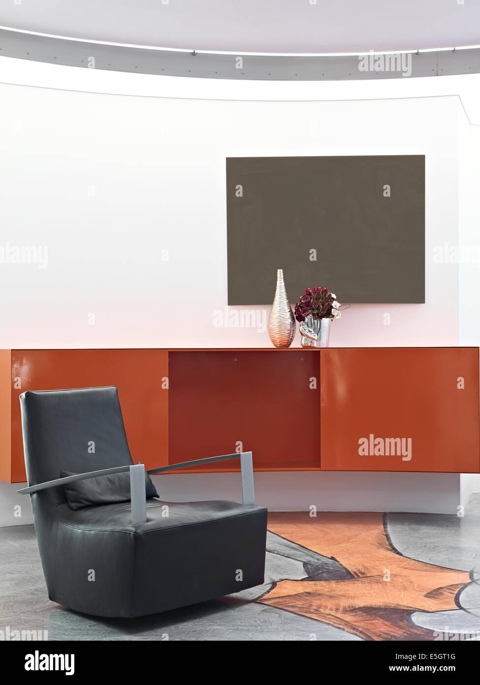 Dettaglio del soggiorno di un soggiorno moderno con mobili rossi sospesa e la resina pavimento decorato Foto Stock