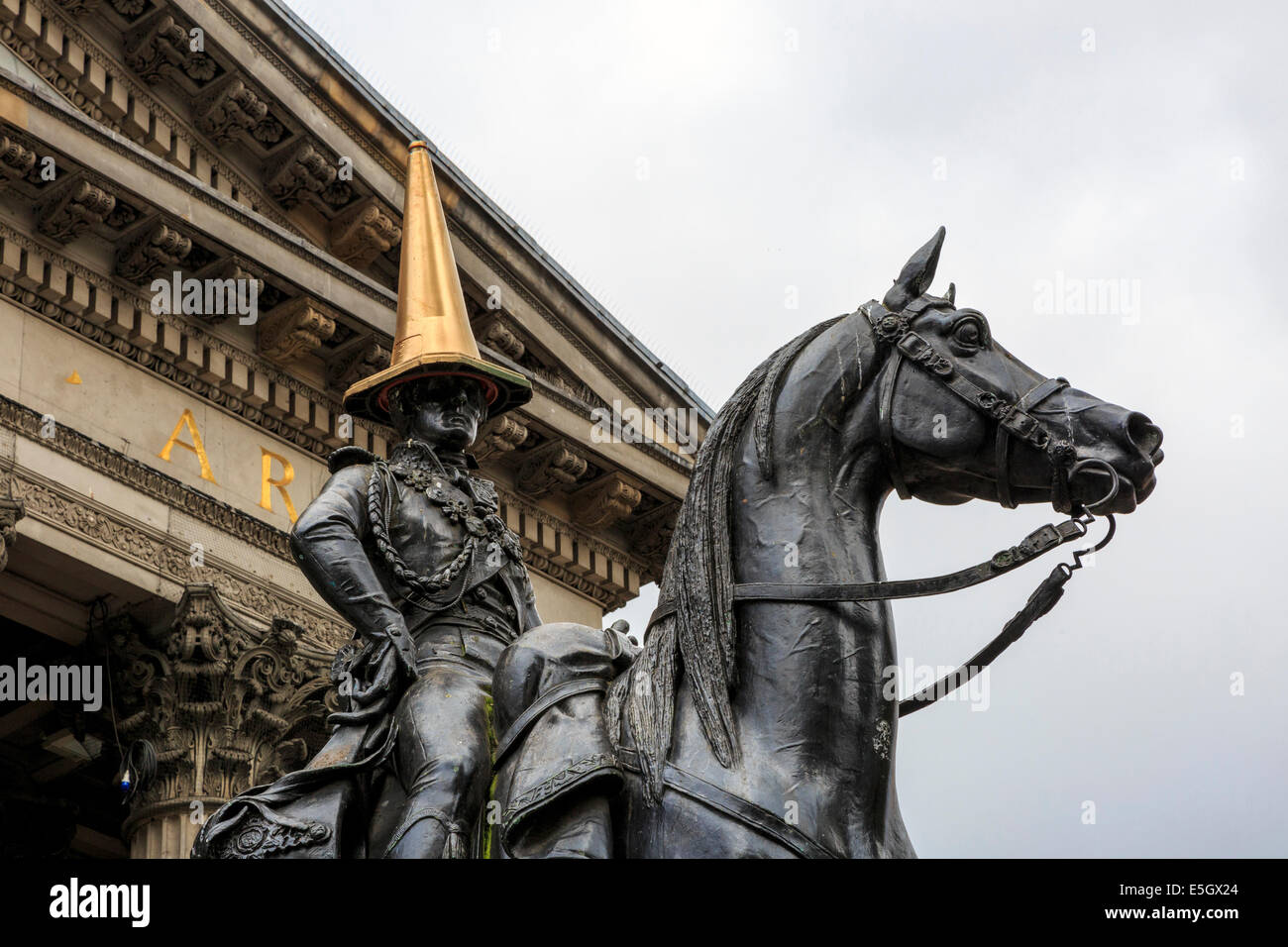 Glasgow, Scotland, Regno Unito. 31 Luglio, 2014. Nella celebrazione del successo dei Giochi del Commonwealth, il regolare e iconico rosso e bianco cono di traffico sulla testa del Duca di Wellington statua (normalmente messi lì come uno studente beffa) è stato sostituito da un dipinto di oro. La statua, con un cono di traffico sulla parte superiore, al di fuori della Galleria di Arte Moderna di Royal Exchange Square è stato utilizzato come un esempio di umorismo Glaswegian ed è un continuo interesse per i turisti e la gente del posto. Credito: Findlay/Alamy Live News Foto Stock