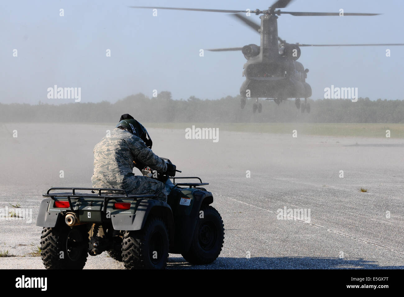 Un U.S. Airman assegnato alla 169a forze di sicurezza Squadron, Carolina del Sud Air National Guard attende come un esercito CH-47 Chinook Foto Stock