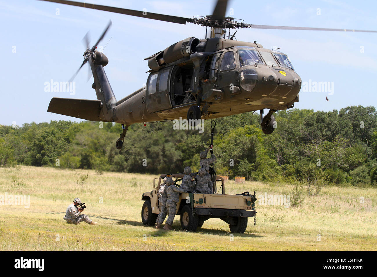 Stati Uniti Soldati gancio a gancio di carico pendente di rilascio per un UH-60 Black Hawk elicottero per imbracare il carico di un M-1097R1 Humvee, durante un fie Foto Stock