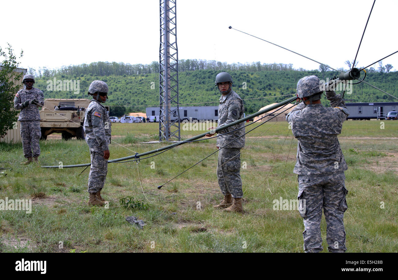 Stati Uniti Soldati con il segnale 187th Company, New York Army National Guard, sollevare un OE254 antenna durante il basate su uno scenario exercis Foto Stock