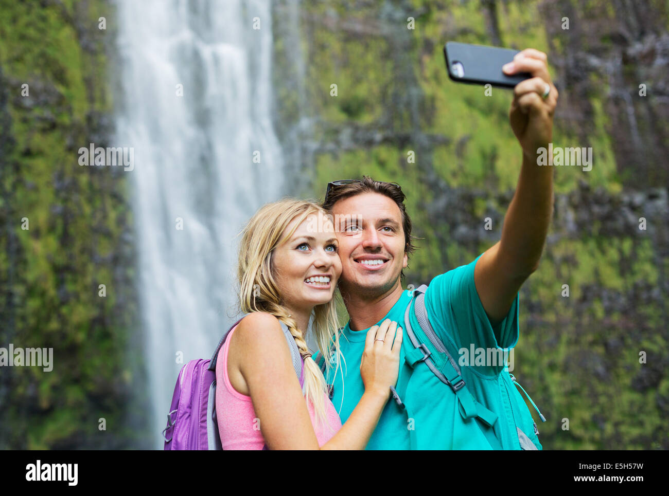 Matura per divertirsi insieme all'esterno. Tenendo autoritratto con la fotocamera del telefono dopo escursioni alle cascate di incredibile nelle Hawaii. Foto Stock