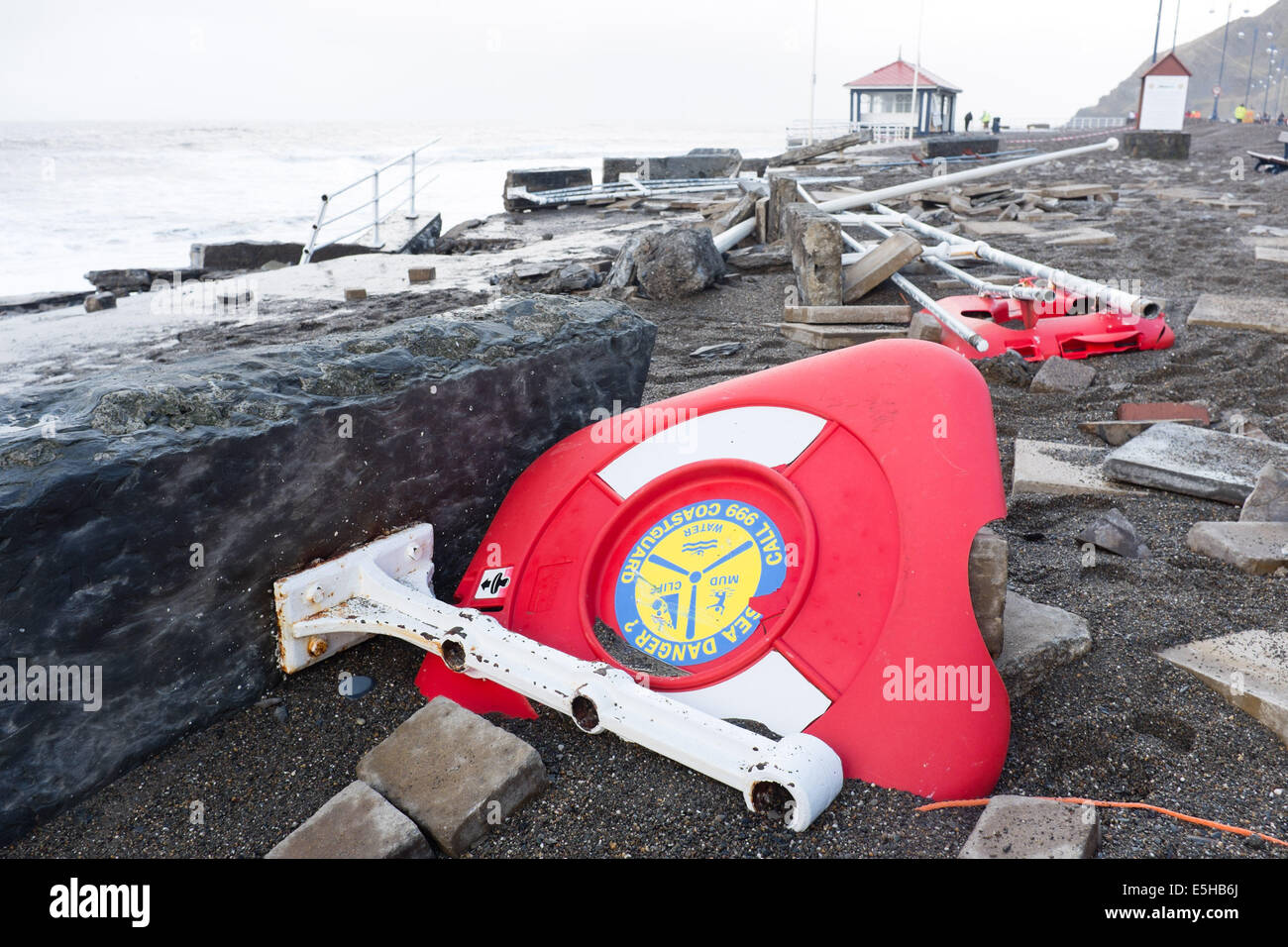 Aberystwyth, Wales, Regno Unito. 03 gennaio 2014. 10-prima: Promenade e ringhiere in mare durante una tempesta. Pulizia dopo la peggior tempesta a colpire Aberystwyth in memoria viva. Ampie parti del lungomare e ringhiere in mare sono stati strappati via durante la violenta tempesta questa mattina. Autorità locale lavoratori stima che il costo della chiarezza e per le riparazioni si; eseguire in diverse centinaia di migliaia di sterline. Un 5.6m alto springtide e gale force south westerly venti portate massive tesse pounding contro il lungomare e il porto a Aberystwyth sulla West Wales coast. Credito: keith morris/Alamy Liv Foto Stock