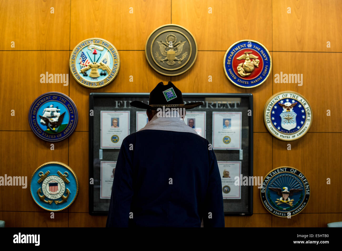 Un pensionato di veterano guarda un servizio militare emblema parete decorata 19 giugno 2014 presso le forze armate di una casa di riposo in Washi Foto Stock