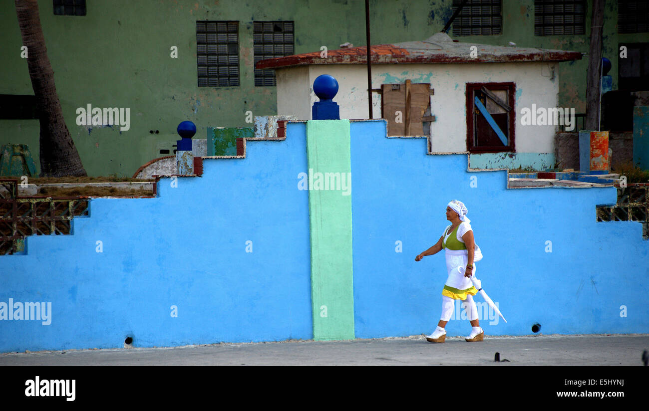 Elegantemente vestito donna a piedi da art deco parete in Havana, Cuba Foto Stock