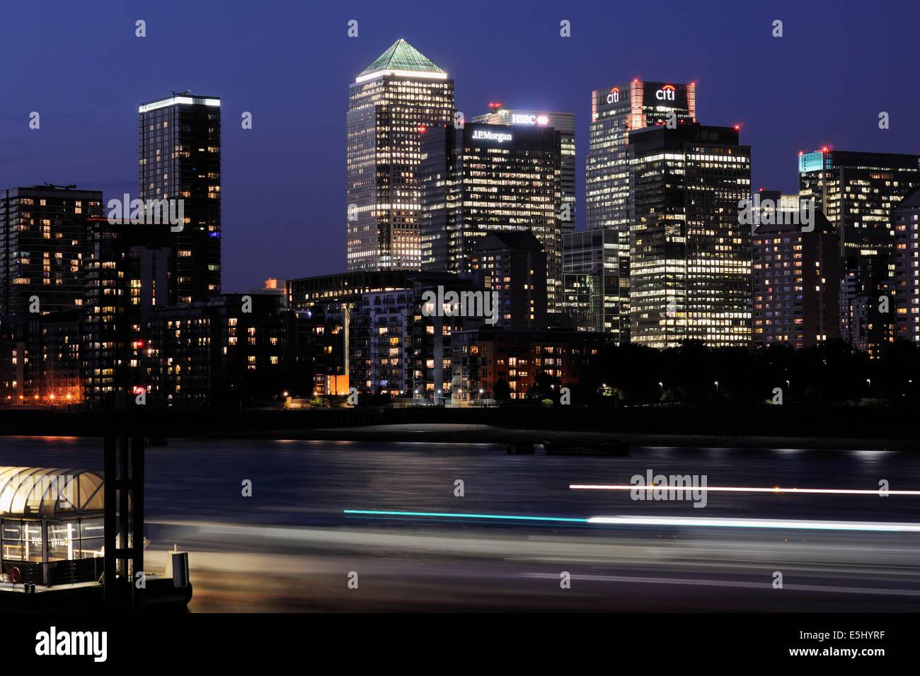 Canary Wharf London REGNO UNITO illuminata di notte, con traffico fluviale Foto Stock