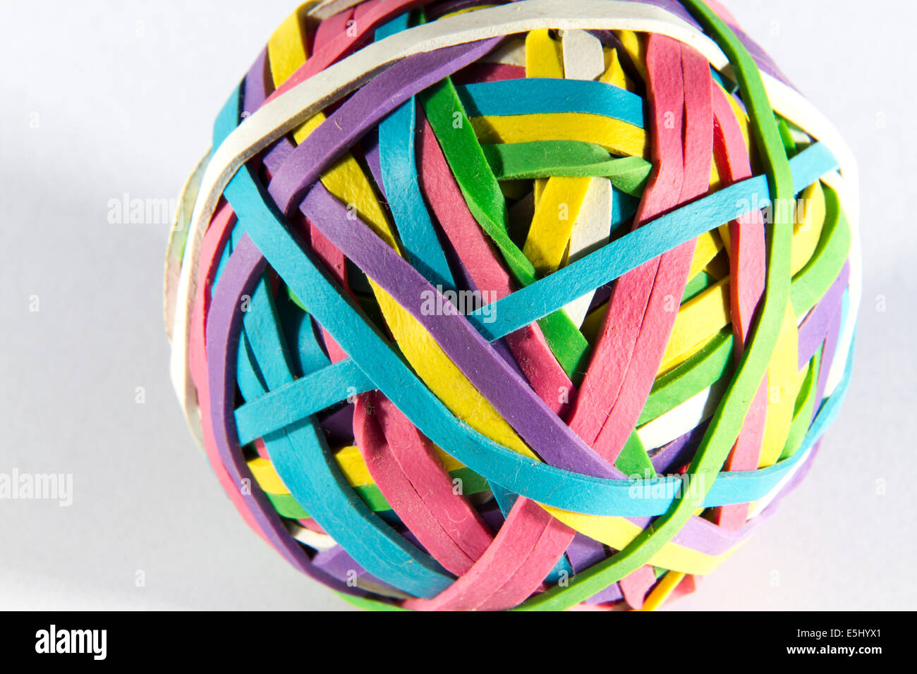 La sfera delle colorate bande di gomma, sfondo bianco, una leggera ombra. Foto Stock