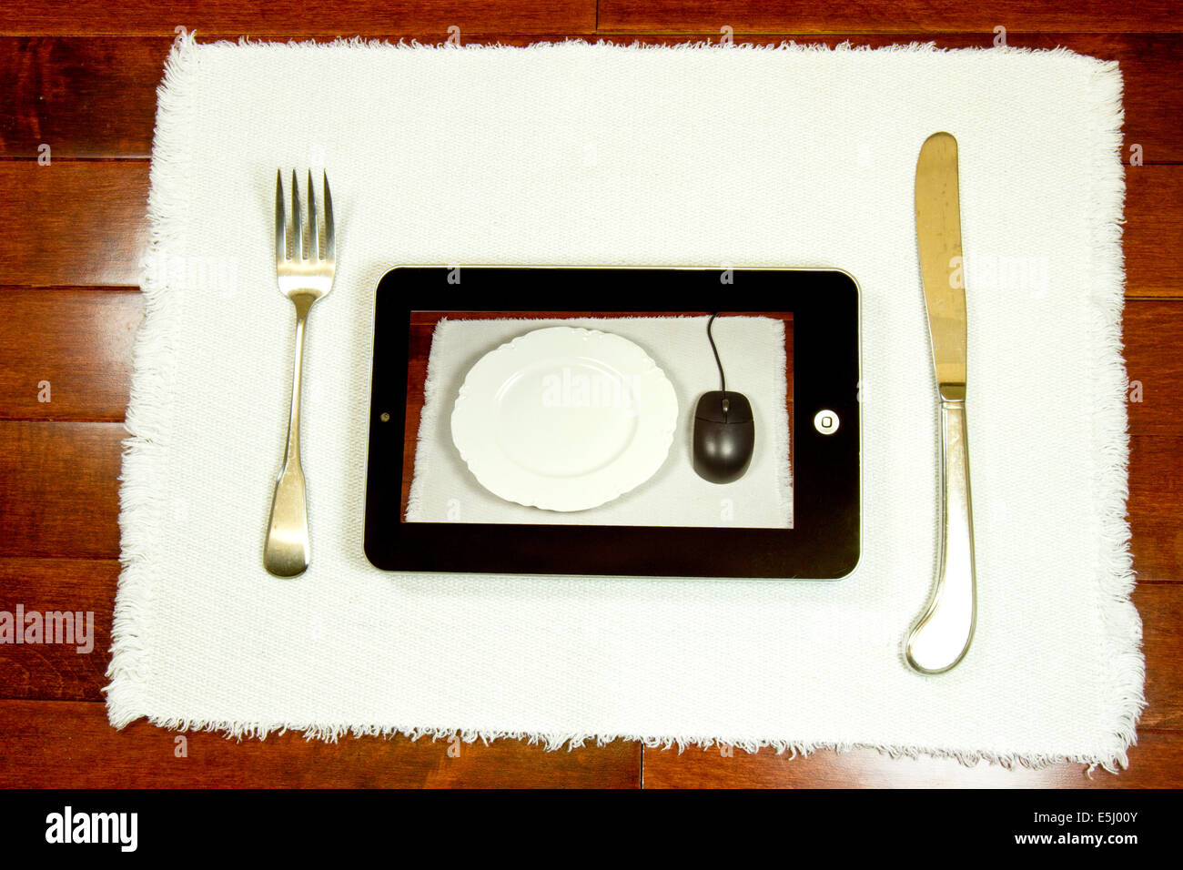 Posizionare il tappetino con coltello, forchetta, la piastra e i computer tablet in rappresentanza di internet recensione del ristorante, ordinazione o prenotazioni Foto Stock