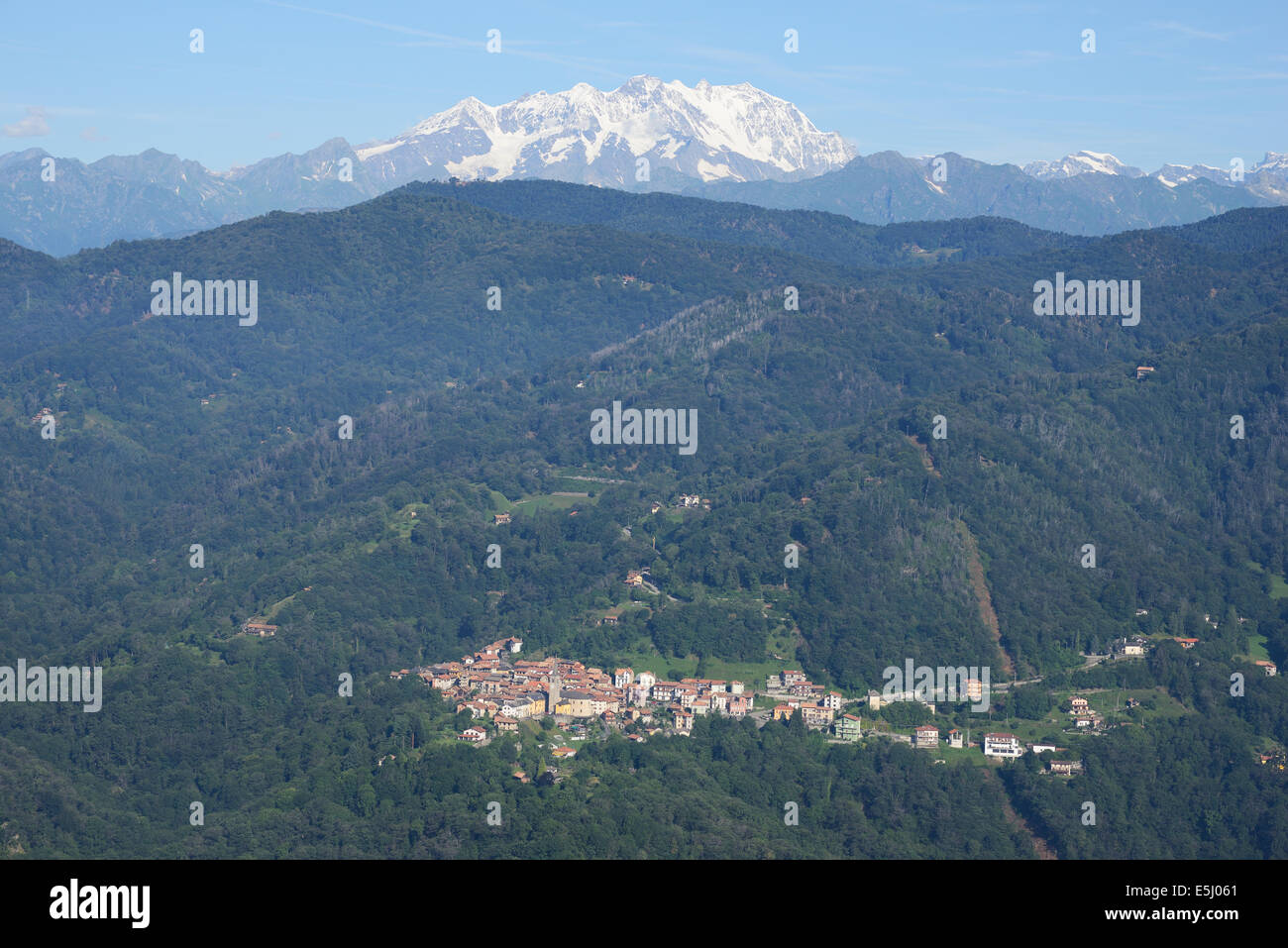 VISTA AEREA. Piccolo borgo di Arola con Monte Rosa (altitudine: 4634 metri) in lontananza. Provincia di Verbano-Cusio-Ossola, Piemonte, Italia. Foto Stock