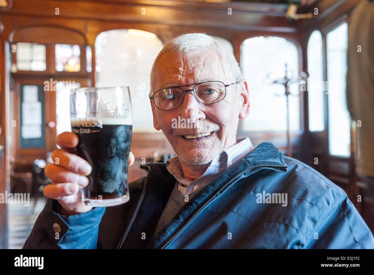 Uomo anziano bere una pinta di Guinness in un pub, REGNO UNITO Foto Stock