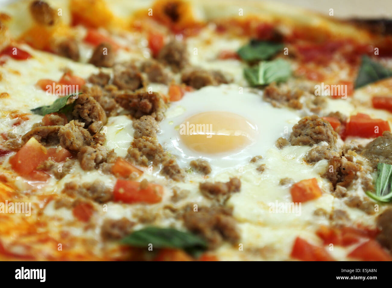 Un uovo-sormontato salsiccia e pizza di carne. Foto Stock