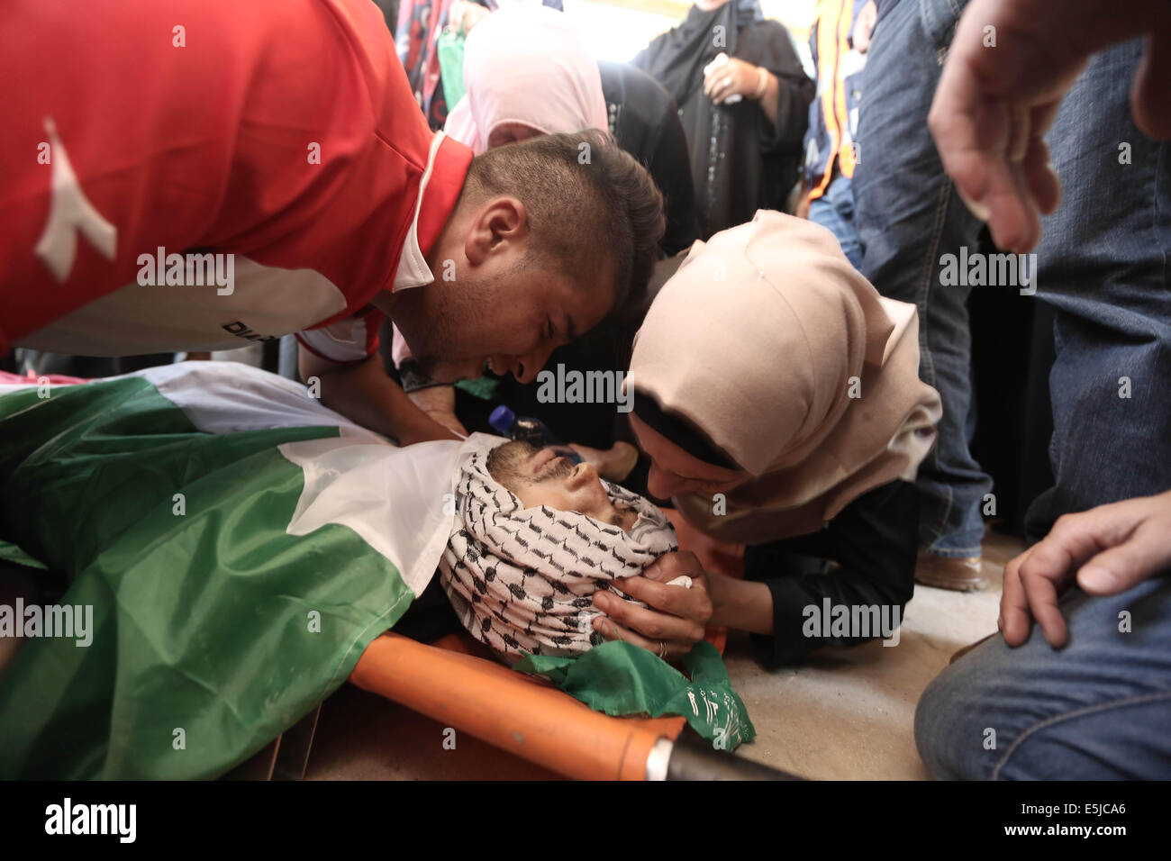 Ramallah. 2 agosto, 2014. Rispetto del palestinese Odai Jaber piangere sopra il suo corpo durante il suo funerale vicino al West Bank città di Ramallah, 2 agosto 2014. Odai Jaber, 19 anni, è stato ucciso durante gli attacchi israeliani. Credito: Fadi Arouri/Xinhua/Alamy Live News Foto Stock