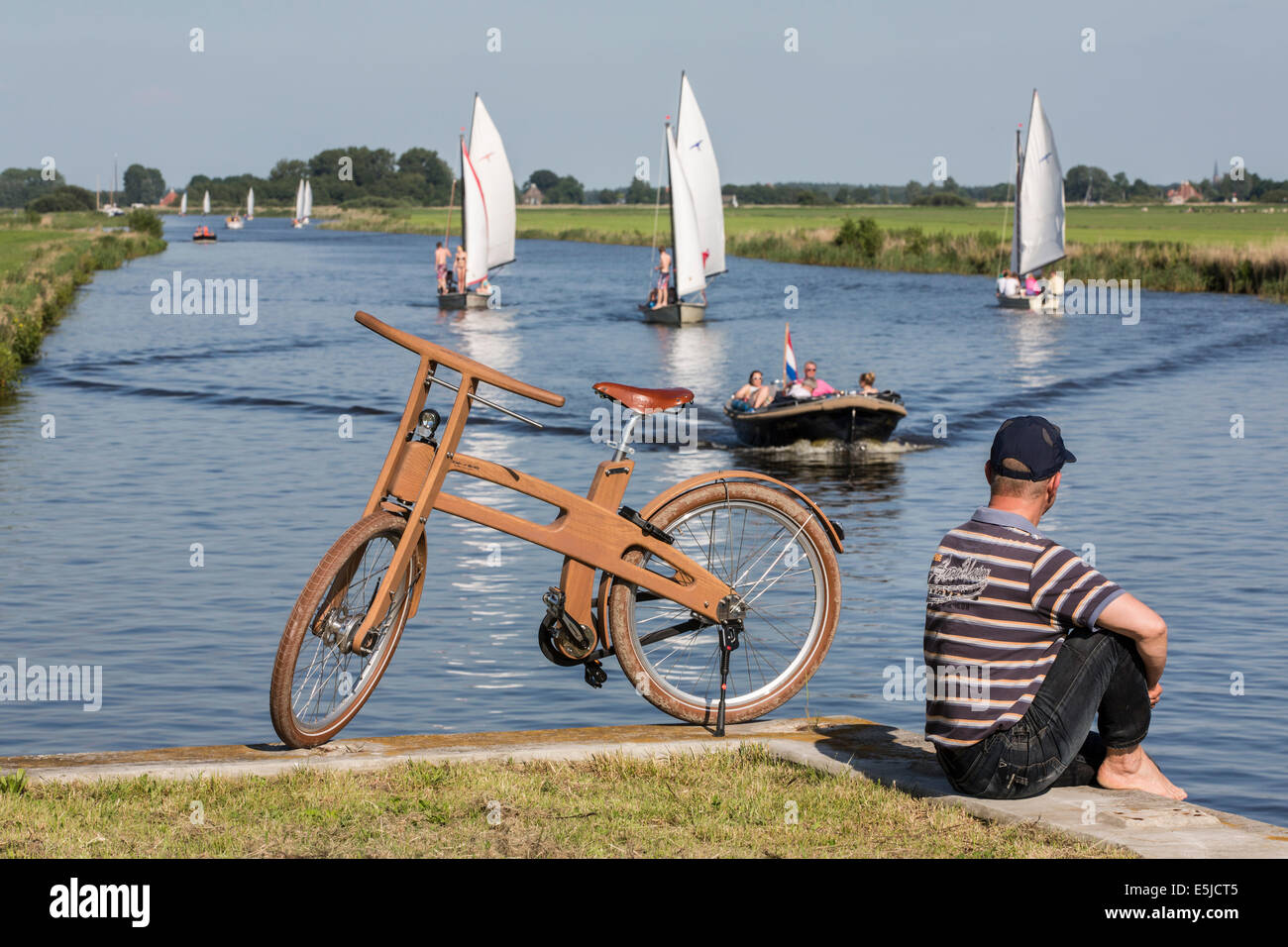 Paesi Bassi, Woudsend, uomo seduto accanto a una fronda Bike. Il design olandese bici in legno è una creazione di Jan Gunneweg Foto Stock