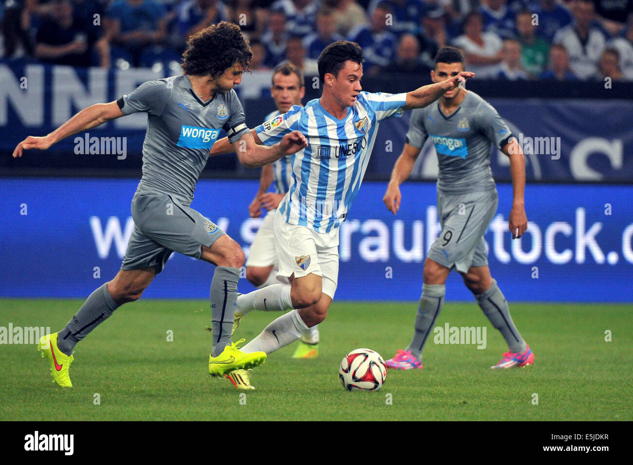 Gelsenkirchen (Germania). 02Aug, 2014. Malaga's Juanmi (C) e di Newcastle, Fabricio Coloccini in azione durante la Schalke Cup match tra FC Malaga e il Newcastle United al Veltins Arena di Gelsenkirchen, Germania, 02 agosto 2014. Foto: Matthias esitano di fronte/dpa/Alamy Live News Foto Stock
