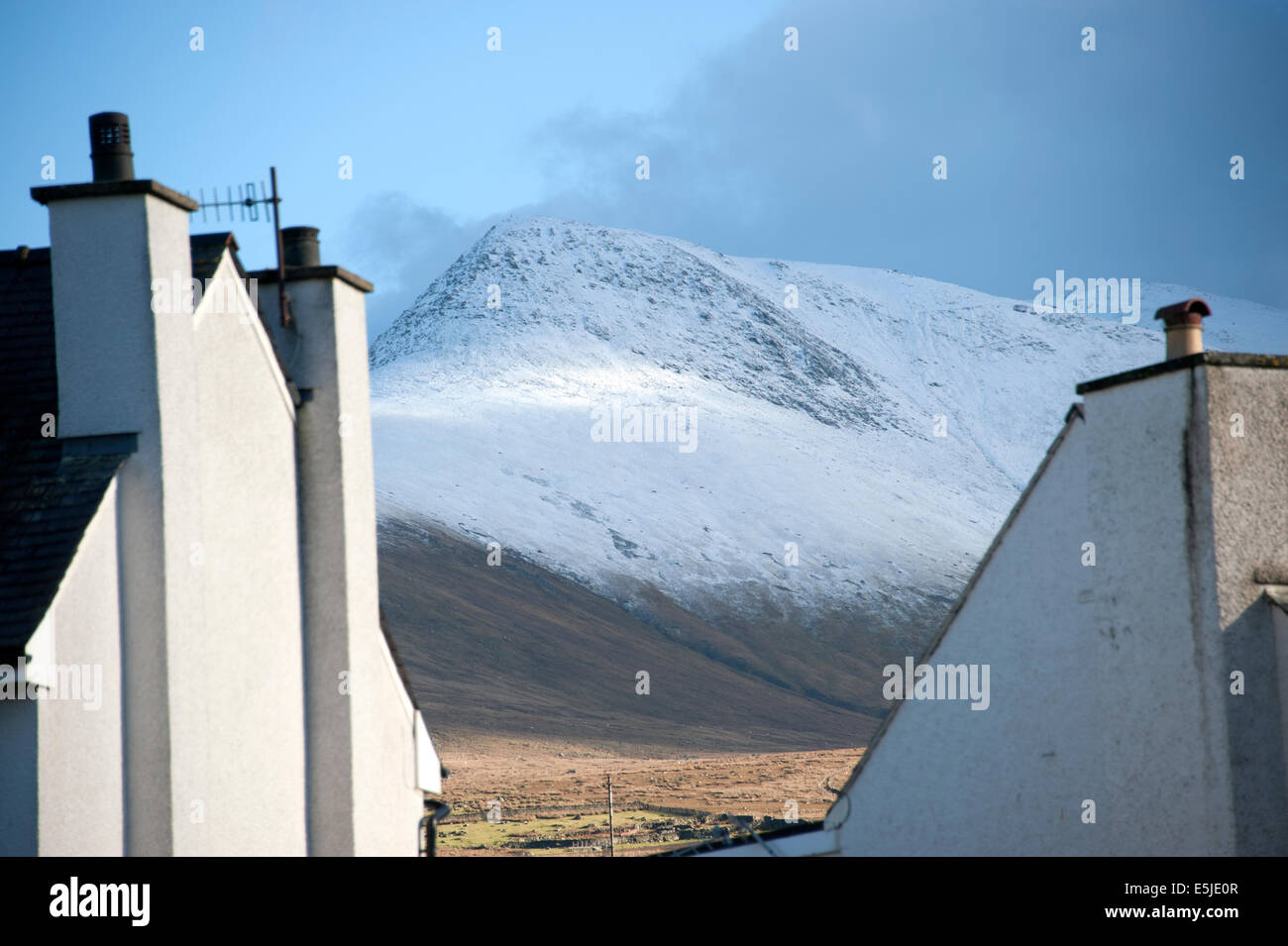 Case con le montagne coperte di neve dietro il Galles del Nord Regno Unito Regno Unito Gran Bretagna Foto Stock