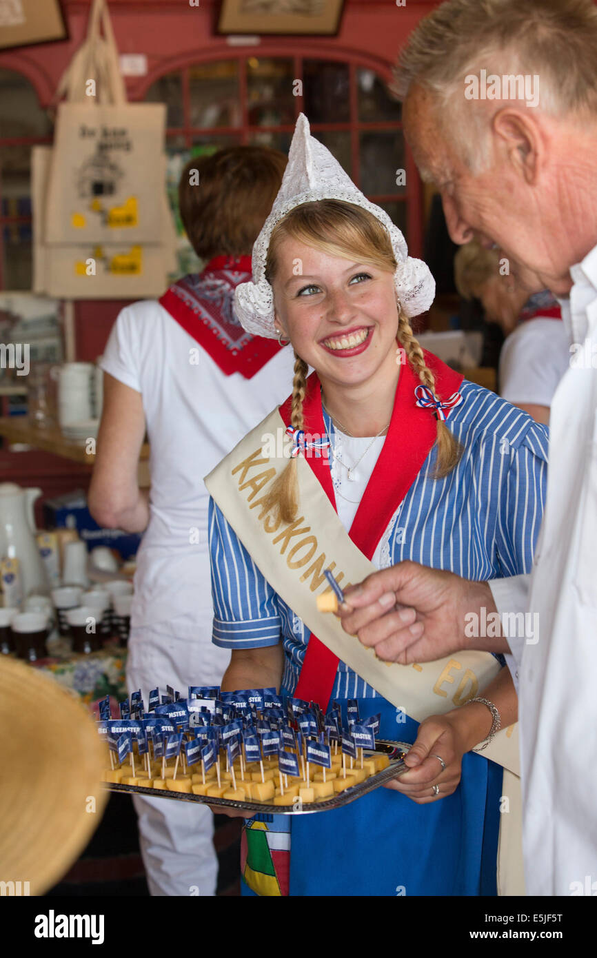 Paesi Bassi, Edam, mercato del formaggio, ragazza in abito tradizionale serve pezzi di formaggio Beemster Foto Stock