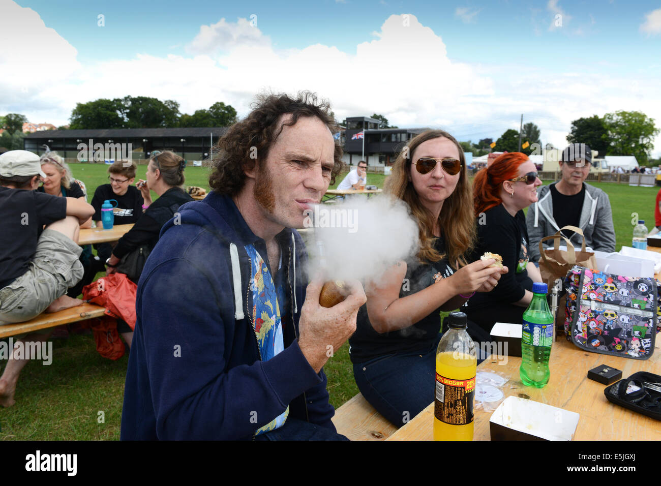 Gli appassionati di vaping si sono scopati sul suo e-pipe all'annuale Vapour Festival 2014. Vaping vape credito elettronico e sigaretta: David Bagnall Foto Stock