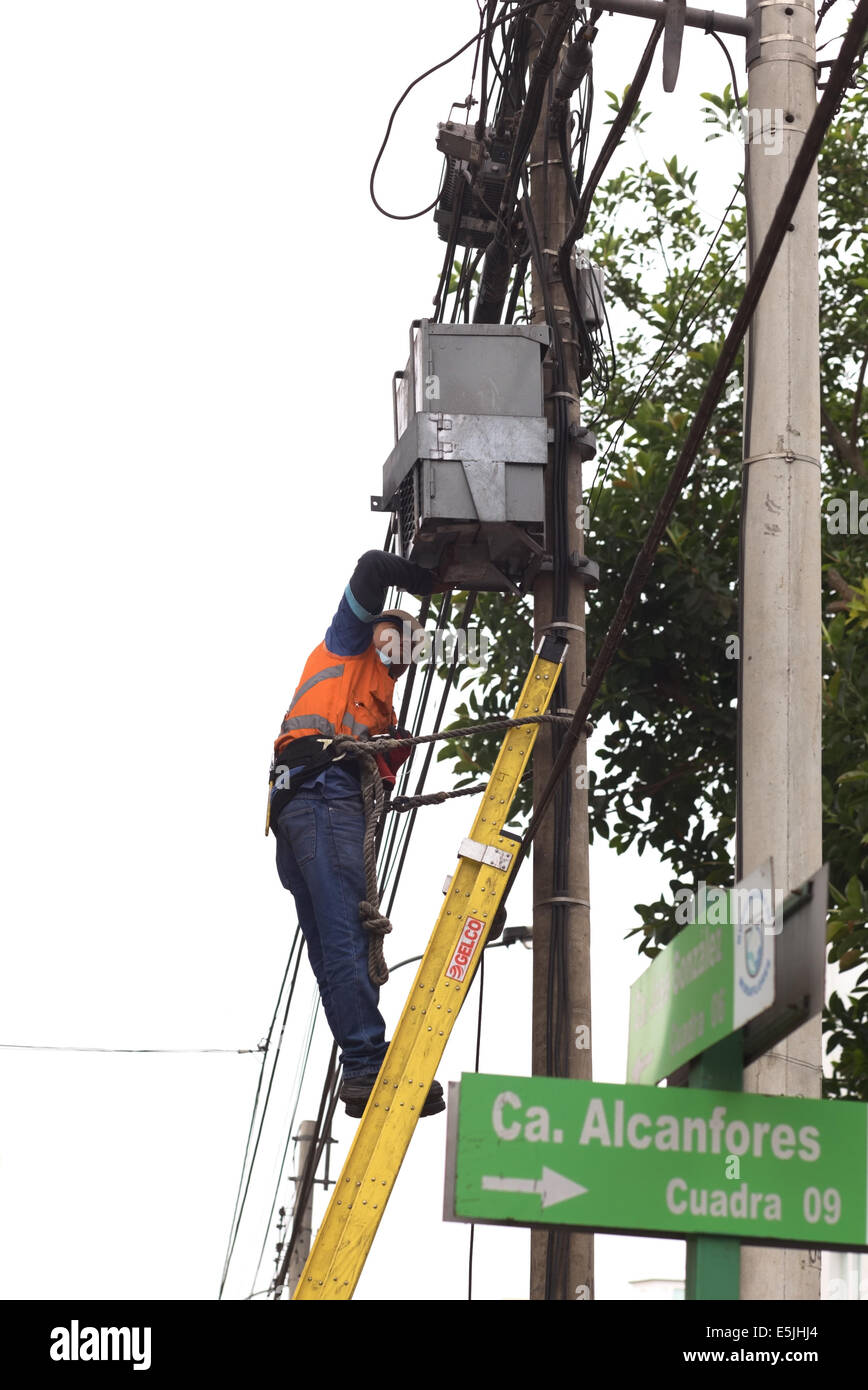 LIMA, Perù - Luglio 23, 2013: Unidentified uomo in piedi sulla scaletta e lavorando su cavi e una casella su un lampione Foto Stock
