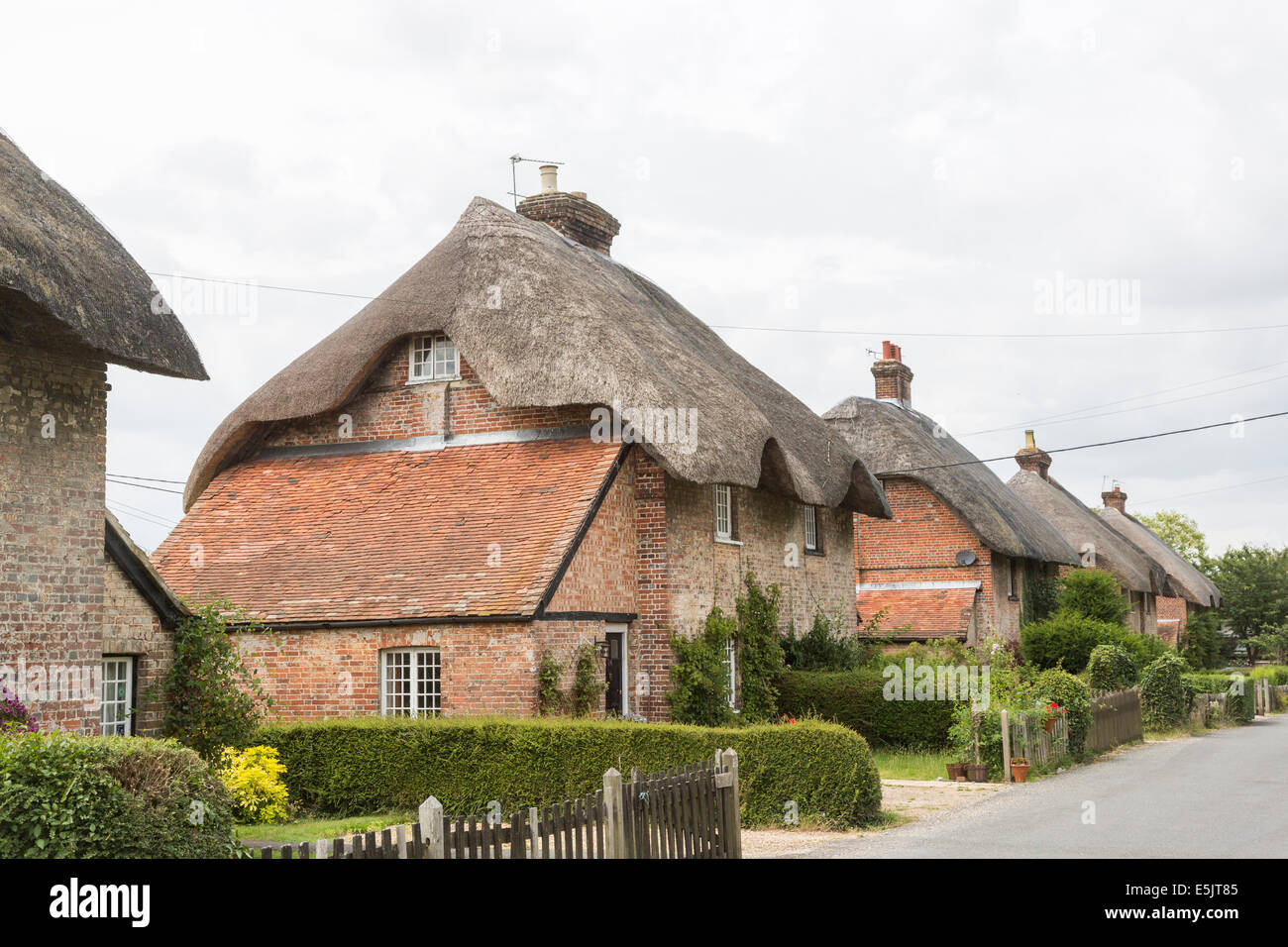 In mattoni tradizionali cottage con il tetto di paglia in Oriente Stratton, un piccolo paese di campagna vicino a Winchester, Hampshire, Regno Unito Foto Stock