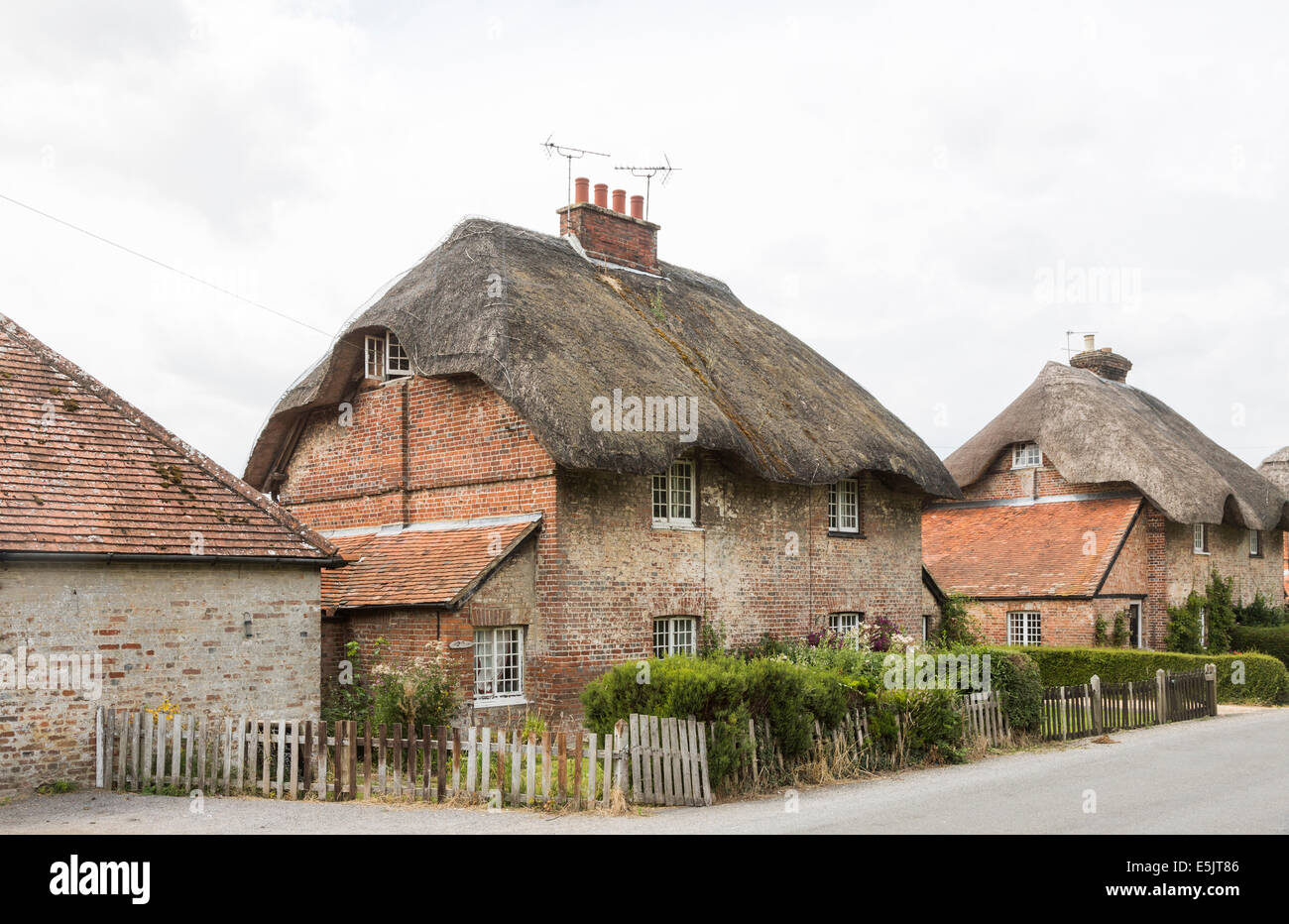 In mattoni tradizionali cottage con il tetto di paglia in Oriente Stratton, un piccolo paese di campagna vicino a Winchester, Hampshire, Regno Unito Foto Stock