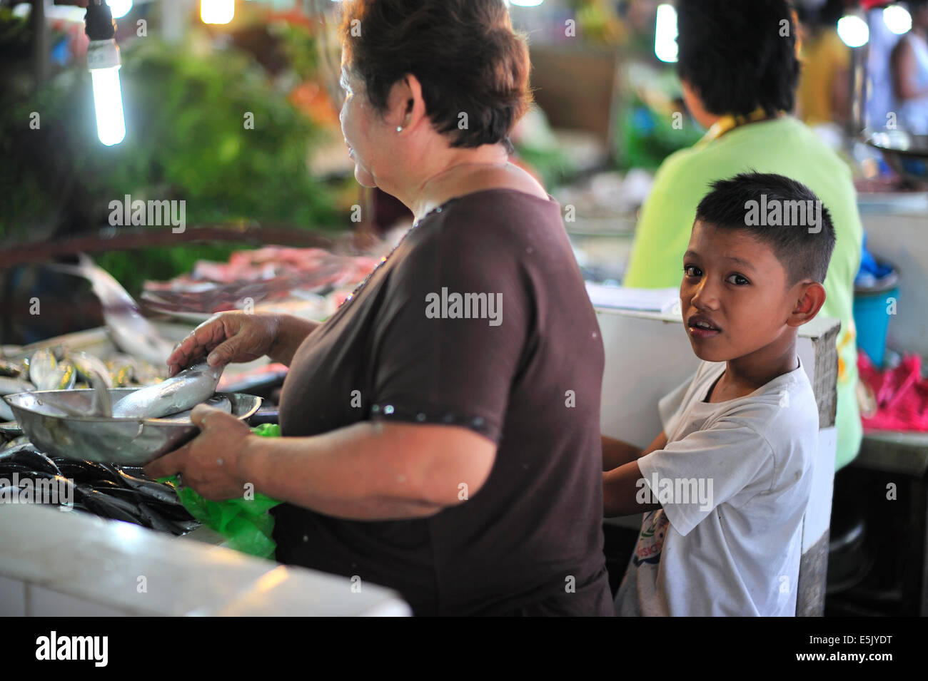 Giovane ragazzo filippino aiuta granny in fresco Lahug mercato alimentare di Cebu Filippine Foto Stock