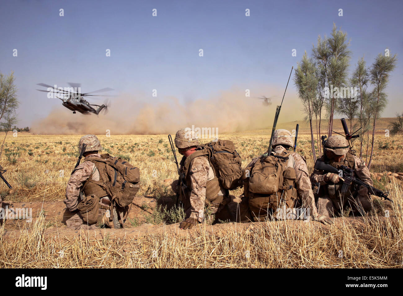 Marines americani con il Primo Battaglione, 7° Reggimento Marine, guarda come CH-53E Super Stallion elicotteri atterra in un campo per il loro prelievo dopo tre giorni di missione Luglio 6, 2014 in Gereshk, provincia di Helmand, Afghanistan. Foto Stock