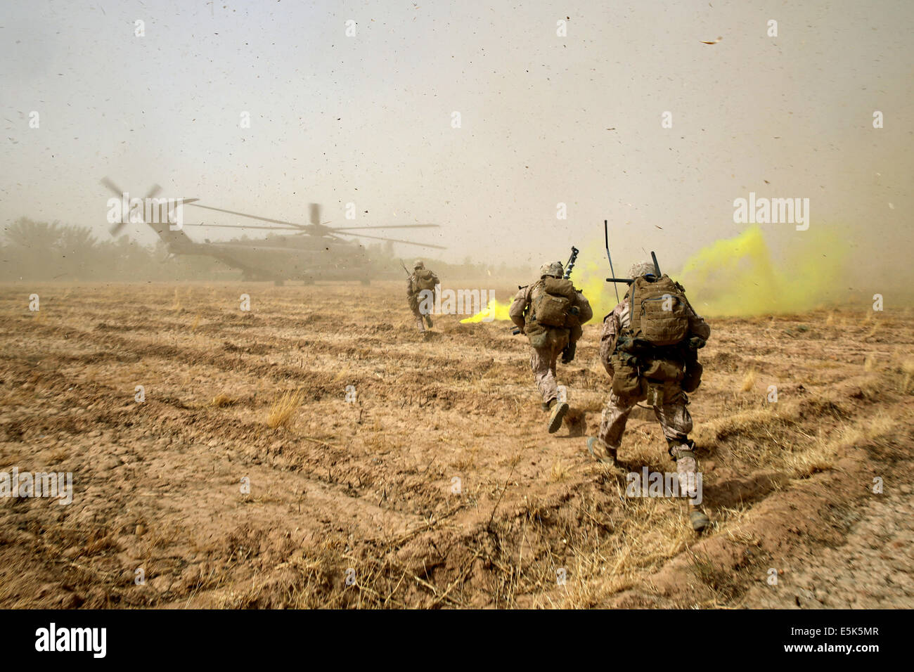 Marines americani con il Primo Battaglione, 7° Reggimento Marine sprint attraverso un campo di carico su una CH-53E Super Stallion elicottero dopo tre giorni di missione Luglio 6, 2014 in Gereshk, provincia di Helmand, Afghanistan. Foto Stock
