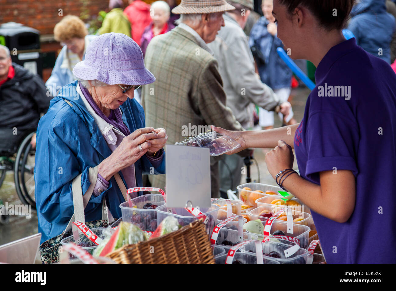 Un membro del pubblico cerca un pezzo di frutta al 2014 Pershore prugna Festival, Pershore, Worcestershire, Inghilterra Foto Stock