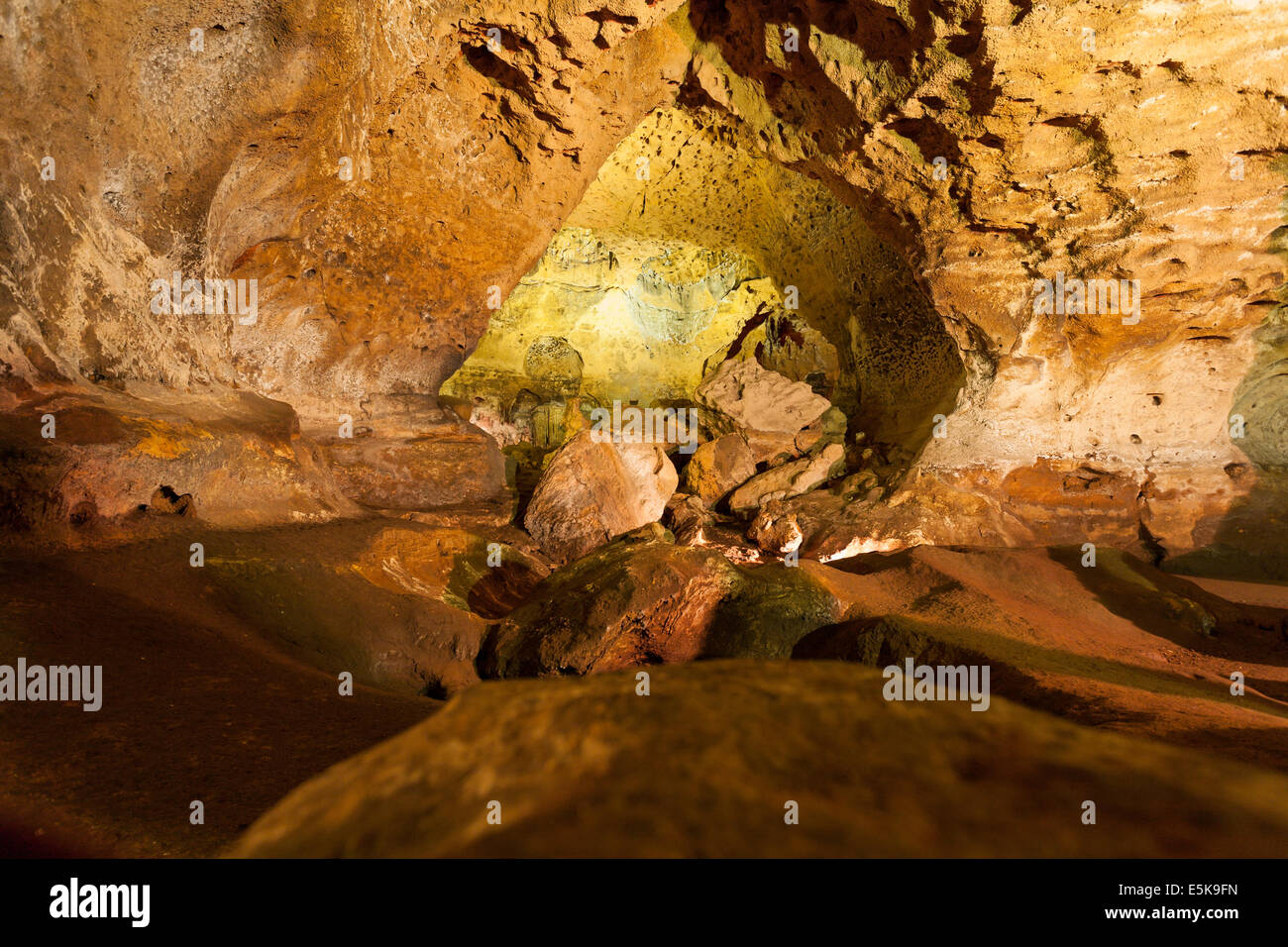 Le grotte di Loltun: dalle tenebre alla luce. Luci elettriche illuminare le fantastiche formazioni. Un giallo brillante grotta è al di là di Foto Stock