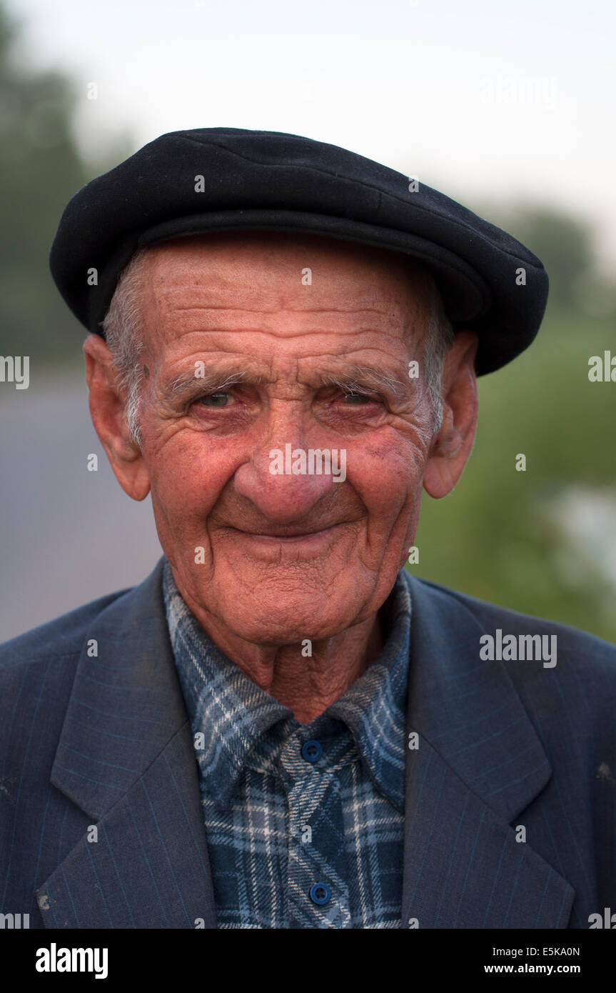 Un anziano armeno con un cappello piatto sorride dolcemente per la telecamera Foto Stock