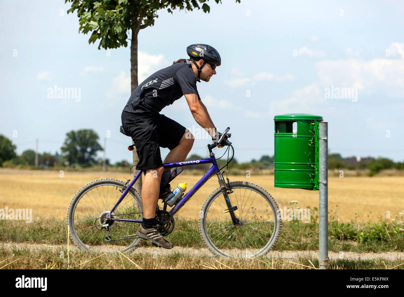 Single man ciclismo da solo ciclista in bicicletta, pista ciclabile nella campagna estiva, cestino rifiuti, attività di stile di vita Repubblica Ceca Foto Stock