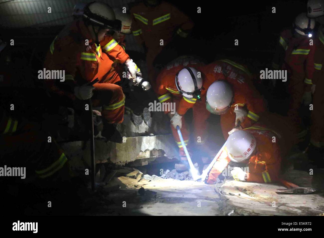 Ludian. Il 4° agosto 2014. Soccorritori tentare di liberare un bambino intrappolato fuori le macerie in quake-hit Zhichang township di Huize County, a sud-ovest della Cina di Provincia di Yunnan, e il Agosto 4, 2014. Almeno 381 persone sono state uccise da Lunedì mattina dopo un 6.5-terremoto di magnitudine agitava la provincia domenica pomeriggio. Credito: Xinhua/Alamy Live News Foto Stock