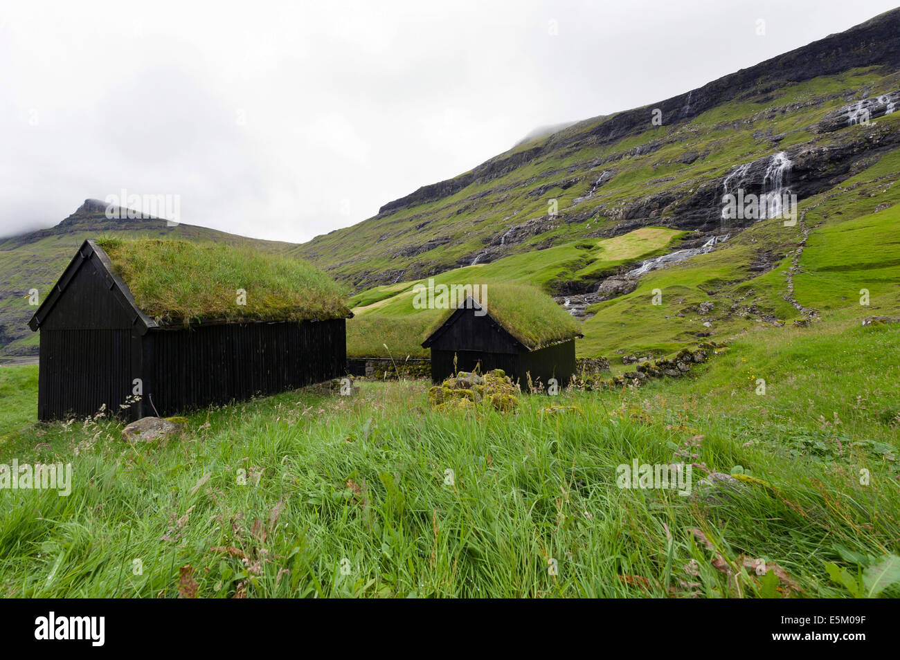 Case con tetti di erba, case di SOD, cascata sul retro, Saksun, Streymoy, Isole Faerøer, Danimarca Foto Stock