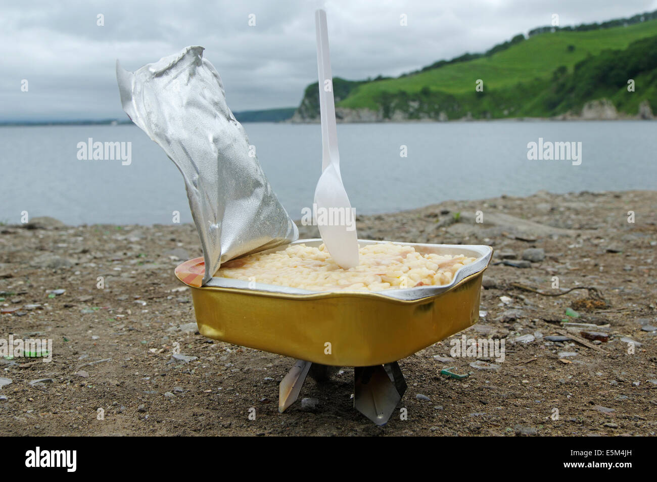 Contenitore di riso fresco, riscaldata su una piastra calda in natura.marching pranzo sulla spiaggia Foto Stock