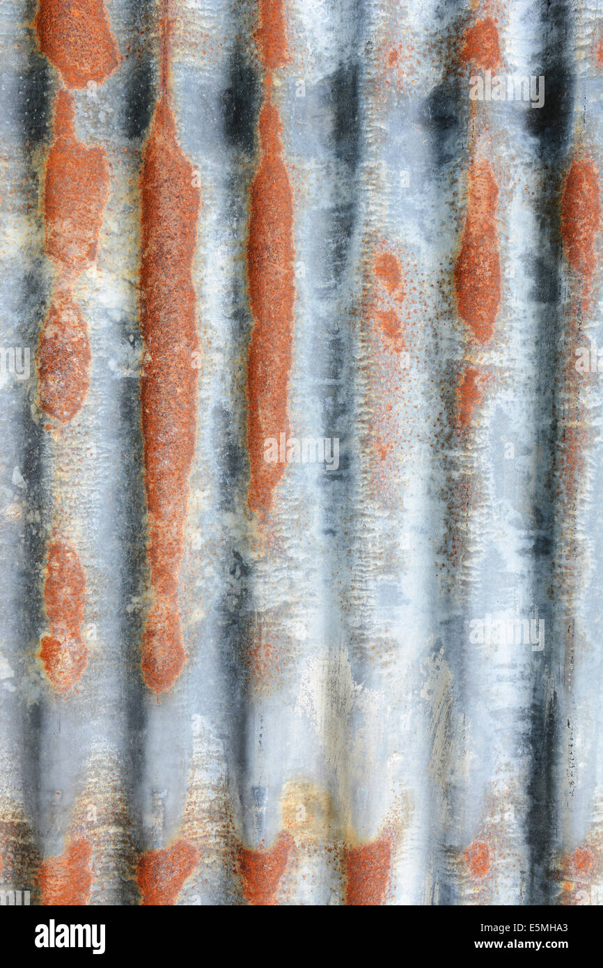 Verticale di ferro ondulato foglio con macchie di ruggine come astratta texture di sfondo Foto Stock