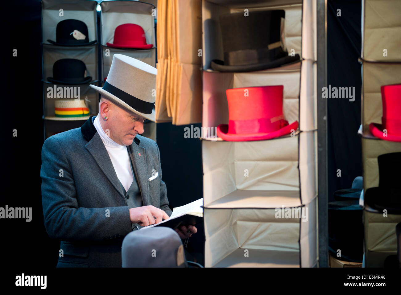 Smart titolare di stallo superiore di vendita cappelli, Spitalfields Market. East London, Regno Unito 2014 Foto Stock