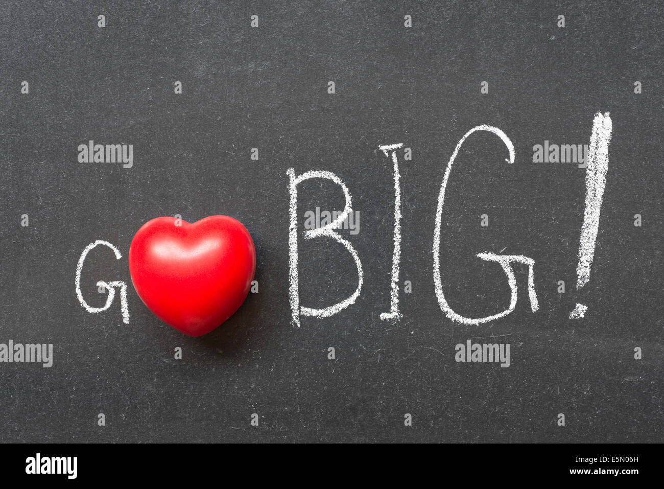 Go Big esclamazione manoscritta su lavagna con il simbolo del cuore di invece di o Foto Stock