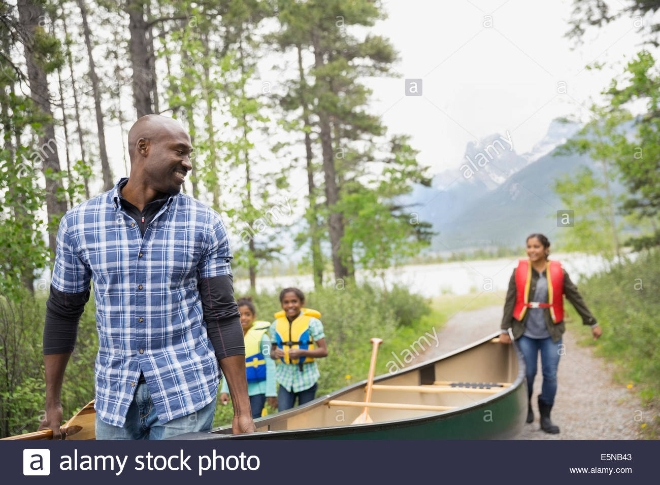 Famiglia canoa porta lontano dal lago Foto Stock